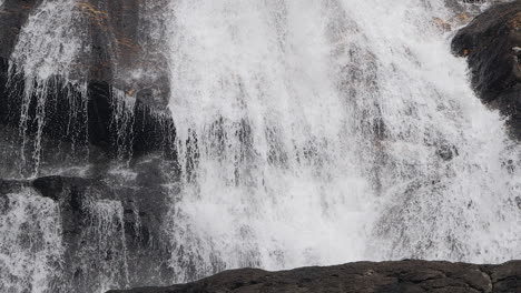 Slow-motion-tracking-shot-along-base-of-majestic-waterfall