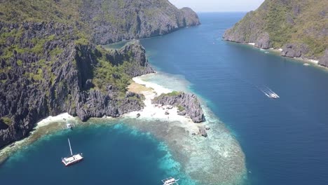 Vista-Aérea-De-Drones-De-4k-De-La-Hermosa-Isla-Privada-En-Filipinas-Con-Un-Barco-Turístico-En-La-Playa-Estrella-De-Distancia-El-Nido,-Palawan