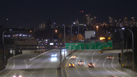 Time-lapse-shot-showing-cars-driving-on-busy-highway-and-flying-airplane-in-Vancouver-at-night
