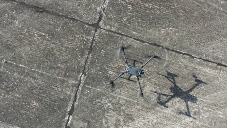 Quadrocopter-Drohnenflugzeug,-Das-Auf-Betonsonnenfläche-Landet,-Luftbild-Von-Oben-Nach-Unten