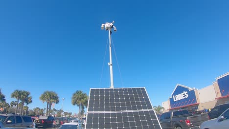 Pan-up-of-a-light-pole-that-is-solar-powered-and-mobile-light-used-for-security-surveillance-in-a-Lowe's-parking-lot