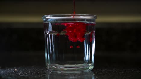 Hot-Melted-Red-Wax-Poured-into-Cold-Glass-of-Clear-Water