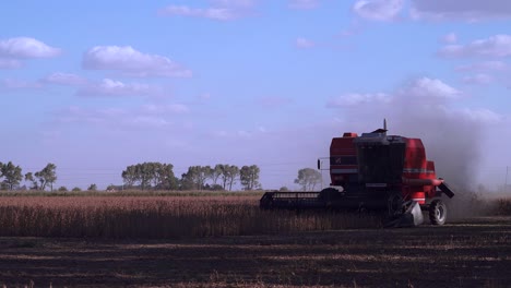 Close-shot-of-a-red-combine-harvesting-soybean-in-a-field-in-rural-Santa-Fe,-Argentina