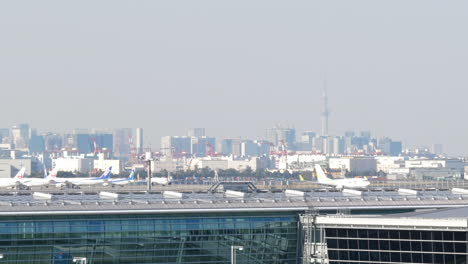Jet-airplane-landing-at-airport-in-front-of-Tokyo-skyscraper-skyline