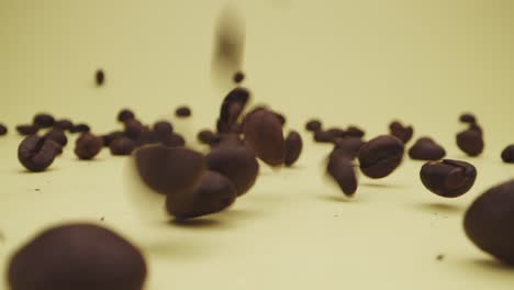 Falling-and-bouncing-of-coffee-beans-on-yellow-background