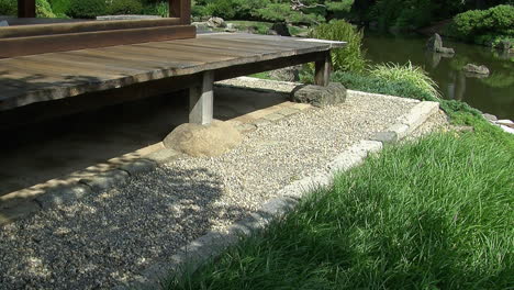 The-gravel-rain-channel-and-engawa-porch-of-a-Japanese-house-with-a-koi-pond-in-the-background