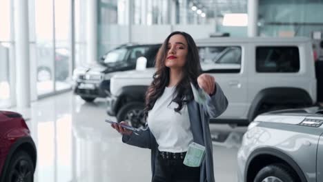 Young-woman-scattering-money-in-a-car-dealership-and-dancing
