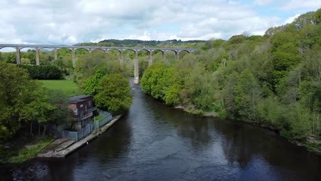Aerial-view-Pontcysyllte-aqueduct-and-River-Dee-canal-narrow-boat-bride-in-Chirk-Welsh-valley-countryside-low-descend