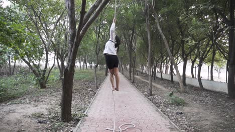 A-sporty-gymnast-performs-exercises-with-a-rope-in-sportswear
