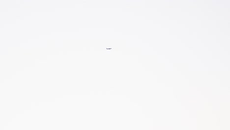 View-Of-An-Airplane-Flying-Through-White-Sky---low-angle-shot