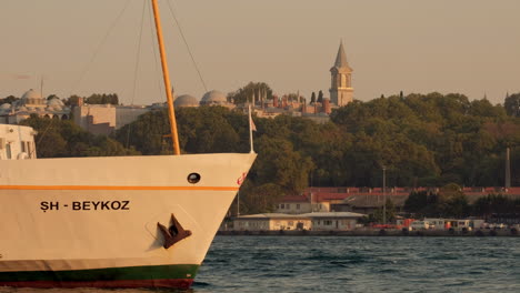 Old-Istanbul-ferry-slowly-departs-at-sunset-with-the-Topkapi-Palace-in-the-background
