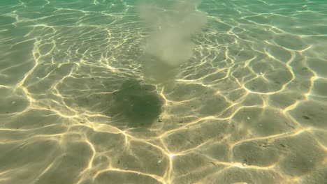 Underwater-Ripple-Sun-Reflection-and-Stone-Falling-to-the-Ground