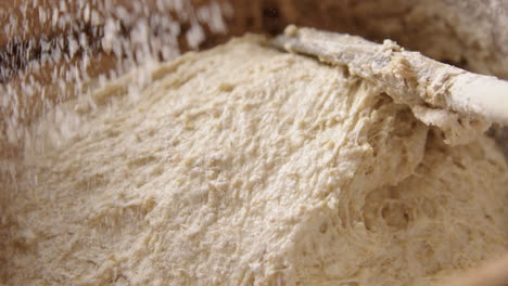 BAKING---Sprinkling-a-little-flour-during-sourdough-bread-baking,-slow-motion