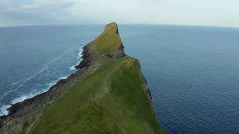 Drone-aerial-footage-of-Worms-head-in-Rhossili-bay-in-the-Gower-peninsula-in-Swansea,-Wales,-with-huge-cliffs