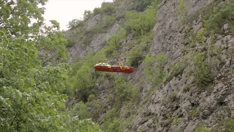 Emergency-stretcher-transported-with-ropes-above-a-canyon-rescuing-an-injured-person