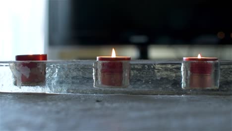 Front-view-of-three-scented-candles-on-a-table-in-the-house
