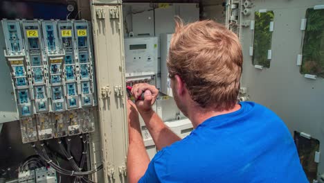 Male-electrician-connects-wires-from-solar-panel-into-electric-power-grid