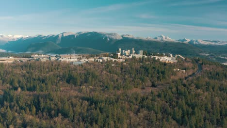 Luftaufnahme-Der-Simon-Fraser-University-Auf-Einem-Hügel-Und-Bergen-Im-Hintergrund-In-British-Columbia,-Vancouver,-Kanada