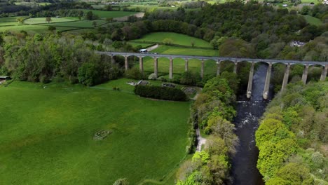 Aerial-view-Pontcysyllte-aqueduct-and-River-Dee-canal-narrow-boat-bride-in-Chirk-Welsh-valley-countryside-dolly-left