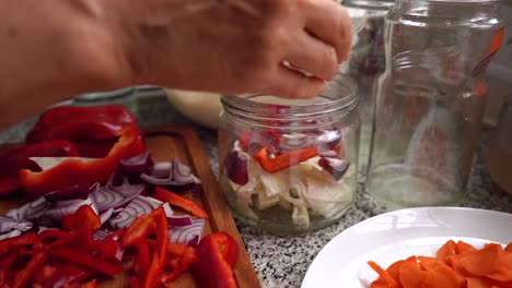 Adding-Chopped-Red-Onions-In-A-Glass-Jar