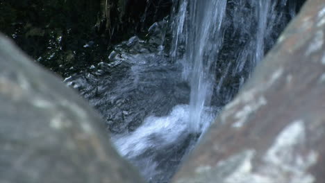 Waterfall-splashes-onto-closely-clustered-rocks