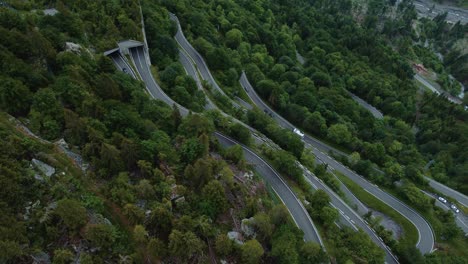 Aerial-view-drone-flight-above-the-scenic-mountain-serpentine-road-Plöckenpass-in-the-natural-Austrian,-Italian-alps-in-summer-with-green-forest-trees-in-nature-and-travel-vacation-cars-on-the-street