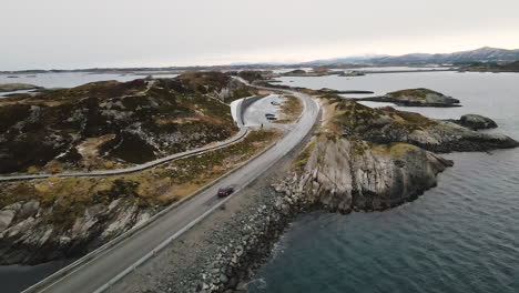 Bmw-Auto-Fährt-Auf-Der-Atlantischen-Ozeanstraße-Mit-Touristen,-Die-Auf-Den-Nationalen-Landschaftsrouten-Von-Eldhusoya-Rund-Um-Die-Insel-In-Norwegen-Wandern