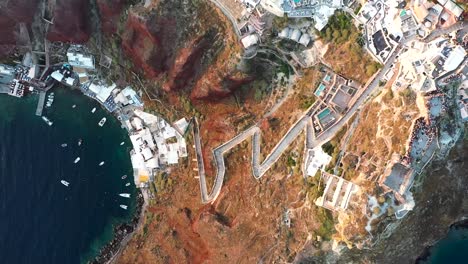 Flight-over-picturesque-village-of-Oia-built-on-a-cliff-during-sunset,-Santorini-island,-Cyclades,-Greece