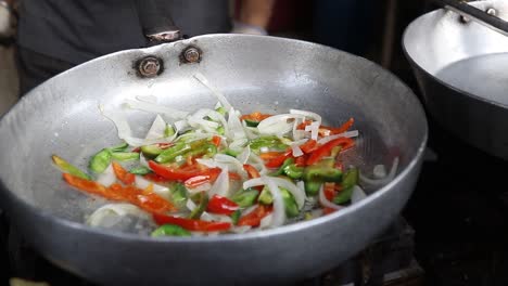 Professional-chef-fries-vegetables-to-prepare-white-sauce-Pasta-at-a-street-food-shop-at-Chat-Gali-in-Agra,-India-on-07-March-2021