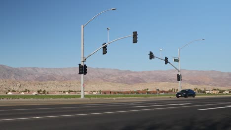Cars-drive-on-Interstate-10-highway-by-Indio-city-in-desert-valley,-California