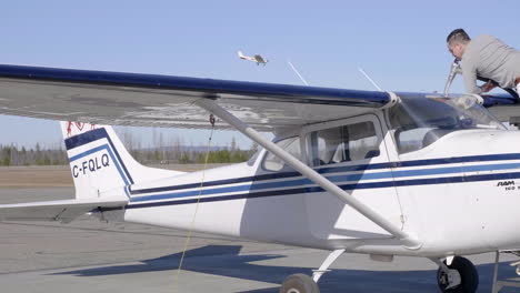 Flughafenbesatzung-Betankt-Cessna-Flugzeug-An-Einem-Sonnigen-Tag-Mit-Flugzeuglandung-Im-Hintergrund