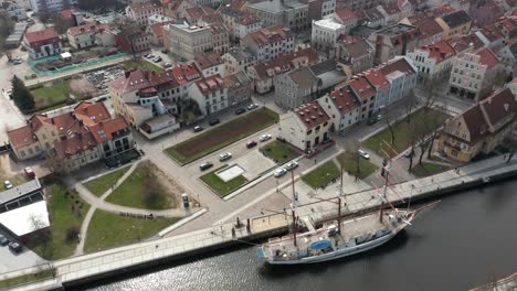 AERIAL:-Barquentine-Sail-Ship-Meridianas-in-Klaipeda-Dane-River-with-Old-Town-and-Port-in-Background