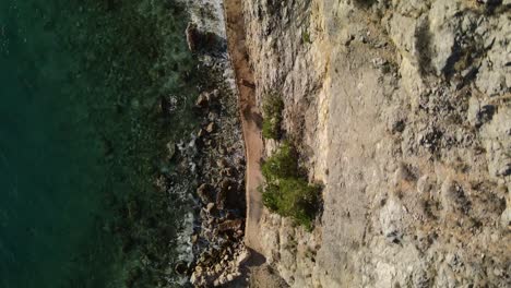 Aerial-Shot-rotating-fast-above-the-woman-walking-in-the-coast-of-Croatia