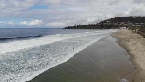 Un-Dron-Vuela-Sobre-Las-Olas-Del-Océano-En-La-Playa-Mientras-Los-Surfistas-Reman-Para-Surfear