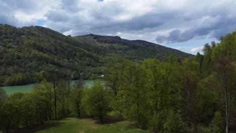 Drone-Shot-Reveal-Turquoise-Lake-At-Mountain