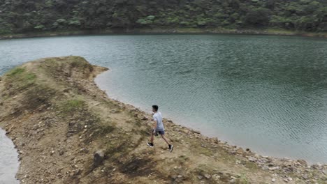 Young-Man-Enjoying-The-Summer-Walk-Along-Lake-Danao-In-Ormoc,-Leyte,-Philippines---Drone-Shot