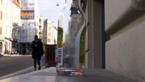 Close-up-of-empty-cider-bottle-outside-bar-in-Gothenburg-city-center
