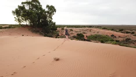 Outdoor-nature-drone-aerial-parralax-woman-walking-sand-hills-desert-outback