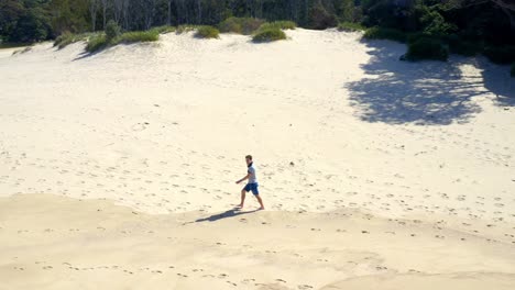 Hombre-Caminando-Solo-En-Una-Duna-De-Arena-En-Un-Día-Soleado-Cerca-Del-Campamento-De-La-Era-Norte-En-El-Parque-Nacional-Real,-Nueva-Gales-Del-Sur,-Australia