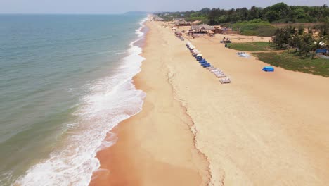 Goa-Sinquerim-Beach-Drone-Vista-De-Pájaro-Drone-Bajando-Hacia-Tilt-up-Volando-Cerca-De-La-Playa-Sobre-Olas