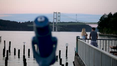 Back-View-Of-Couple-At-Waterfront-Tacoma-Narrows-Bridge-In-Kitsap-Peninsula---medium-shot