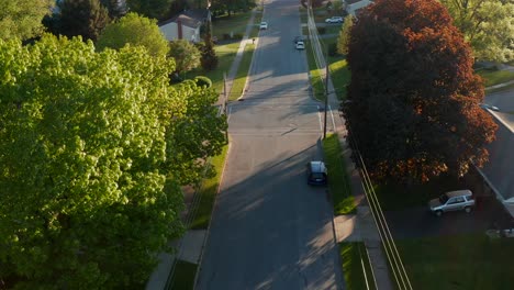 Descending-aerial-on-quiet-street-in-neighborhood-town,-outskirts-of-American-city-in-USA