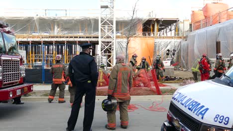 Police-and-firefighters-investigating-on-a-industrial-construction-site,-static-shot
