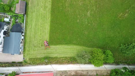 Rasenmäher-Traktor,-Der-Gras-Schneidet,-Während-Er-Die-Nachbarschaft-Der-Siedlung-Reinigt