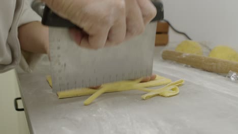 Cutting-off-and-forming-the-pasta-dough-with-kitchen-knife