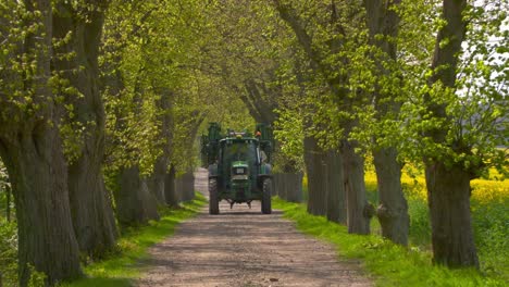 Tractor-with-sprayer-driving-down-wooden-alley
