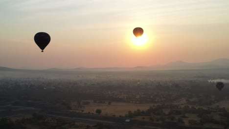 Aerial-view-of-hot-air-baloon-flying-over-in-Teotihuacan-Mexico-during-foggy-sunrise,-4