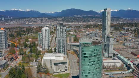 Beautiful-drone-shot-of-Surrey-City-Centre-and-North-Shore-Mountains-on-a-sunny-summer-day-in-British-Columbia-Canada-in-UHD