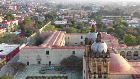 Aerial-View-of-Santo-Domingo-de-Guzman-Church-and-Square-in-Historic-Downtown-of-Oaxaca-City,-Mexico,-Revealing-Pull-Back-Drone-Shot