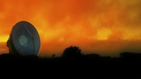 Vibrant-orange-red-sunset-clouds-moving-slowly-over-a-large-Satellite-array